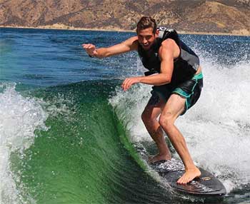 Man with Life Jacket Surfing on a Rambler Wakesurf Board