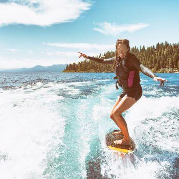 Girl Wakesurfing Behind a Boat on a Lake