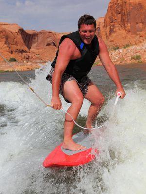 Man Pumping Wakesurf Board to Speed Up Board and reach the Sweet Spot Behind the Boat